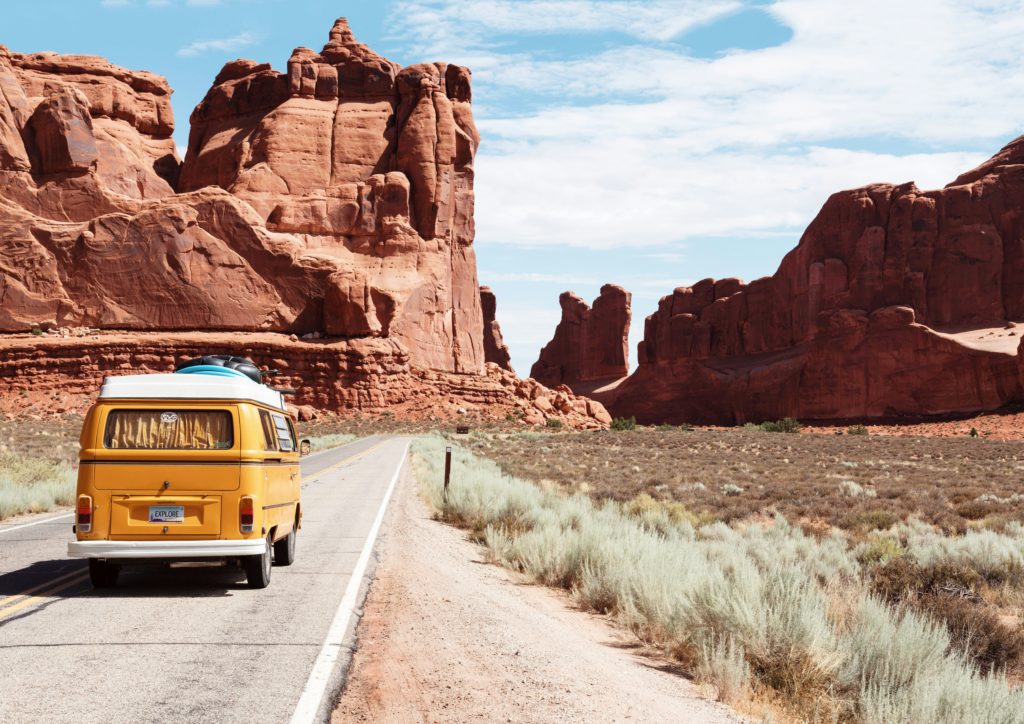 Camper auf einer Straße durch weite Landschaft
